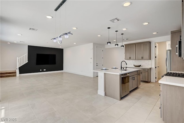 1305 Azure Jay Ave, North Las Vegas, NV 89084 - kitchen with stainless steel appliances, backsplash, light countertops, a center island with sink, and recessed lighting
