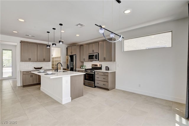1305 Azure Jay Ave, North Las Vegas, NV 89084 - kitchen with appliances with stainless steel finishes, backsplash, a center island with sink, light countertops, and recessed lighting