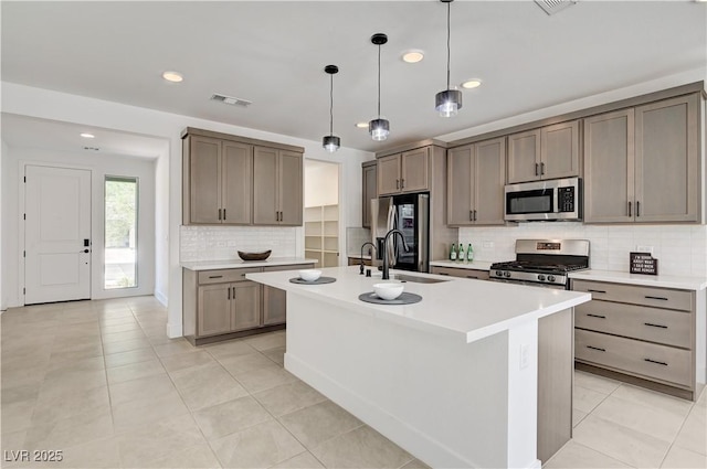 1305 Azure Jay Ave, North Las Vegas, NV 89084 - kitchen featuring stainless steel appliances, backsplash, recessed lighting, a kitchen island with sink, and light countertops