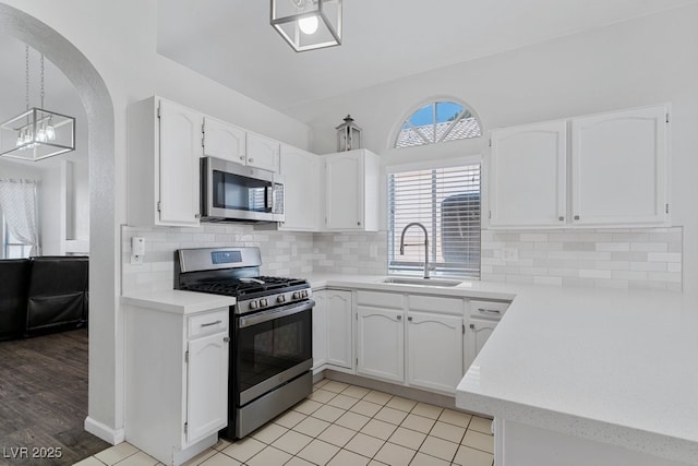 5621 Desert Creek Way, Las Vegas, NV 89149 - kitchen with appliances with stainless steel finishes, white cabinetry, light countertops, a chandelier, and decorative backsplash
