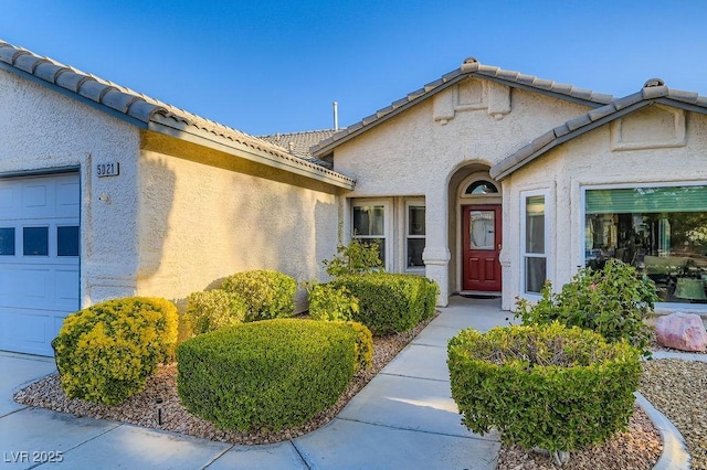 5021 Cliffrose Dr, Las Vegas, NV 89130 - property entrance with stucco siding, an attached garage, and a tile roof