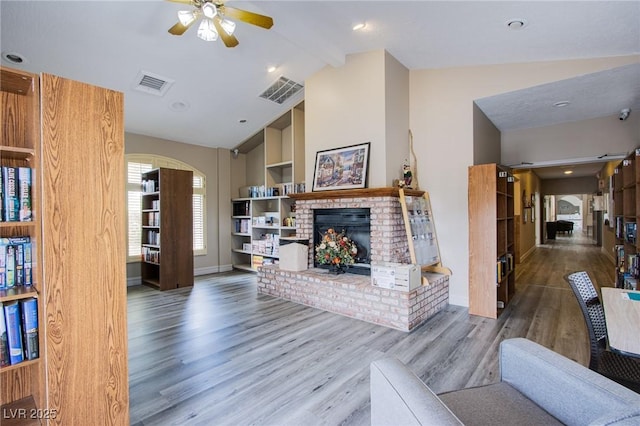 5021 Cliffrose Dr, Las Vegas, NV 89130 - living area featuring lofted ceiling, a ceiling fan, a fireplace, wood finished floors, and arched walkways