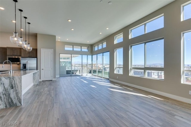 4152 Yucca Bloom St Unit 1, Las Vegas, NV 89135 - unfurnished living room with light wood-style floors, recessed lighting, and a high ceiling