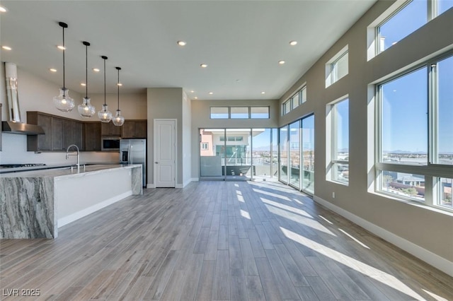 4152 Yucca Bloom St Unit 1, Las Vegas, NV 89135 - kitchen with stainless steel appliances, recessed lighting, dark brown cabinets, light wood finished floors, and open floor plan