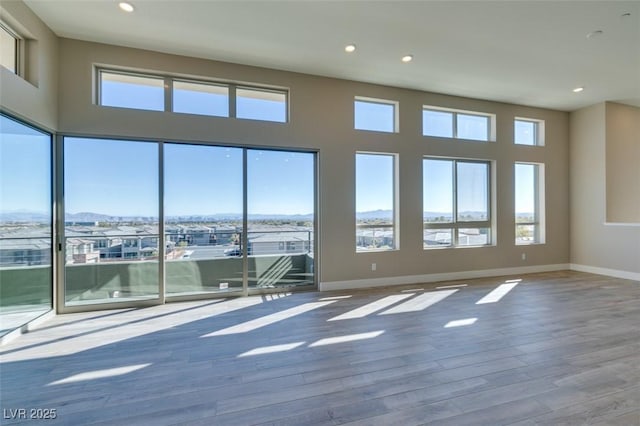 4152 Yucca Bloom St Unit 1, Las Vegas, NV 89135 - unfurnished room featuring healthy amount of natural light, wood finished floors, recessed lighting, and a mountain view