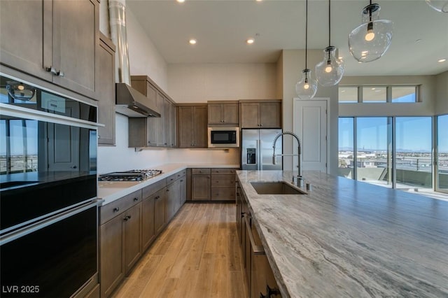 4152 Yucca Bloom St Unit 1, Las Vegas, NV 89135 - kitchen featuring black appliances, light wood finished floors, recessed lighting, pendant lighting, and light stone counters
