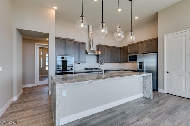 4152 Yucca Bloom St Unit 1, Las Vegas, NV 89135 - kitchen featuring stainless steel appliances, light wood-style flooring, dark brown cabinetry, light stone countertops, and recessed lighting