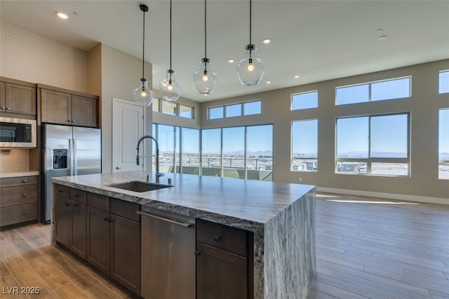 4152 Yucca Bloom St Unit 1, Las Vegas, NV 89135 - kitchen with appliances with stainless steel finishes, light wood-style flooring, recessed lighting, open floor plan, and a kitchen island with sink