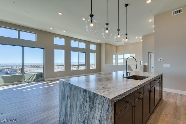 4152 Yucca Bloom St Unit 1, Las Vegas, NV 89135 - kitchen with open floor plan, recessed lighting, light wood finished floors, light stone counters, and pendant lighting