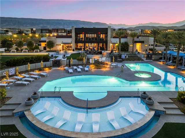 4152 Yucca Bloom St Unit 1, Las Vegas, NV 89135 - pool at dusk with a community pool, a patio, and a mountain view