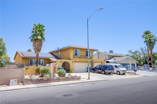 5134 Caliente St, Las Vegas, NV 89119 - view of front of home with an attached garage, stucco siding, roof mounted solar panels, and driveway