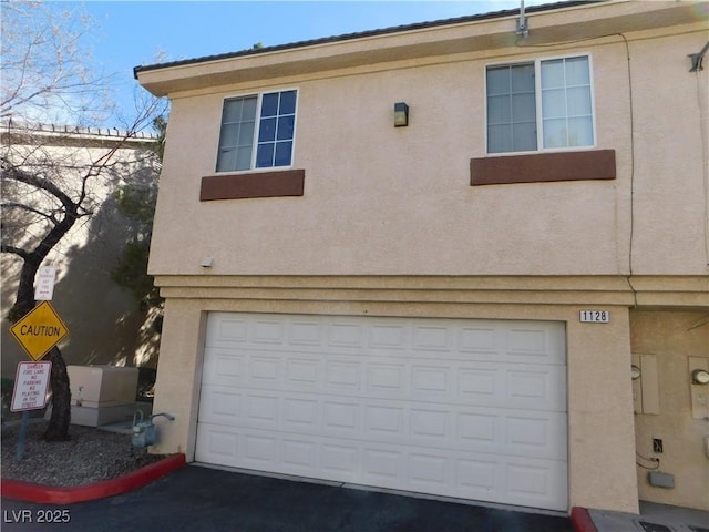 1128 Dusty Creek St, Las Vegas, NV 89128 - view of front of house with stucco siding, an attached garage, and driveway