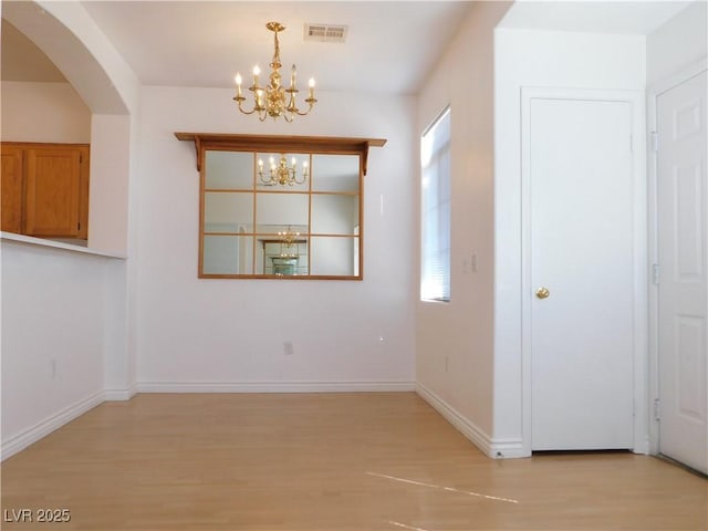 1128 Dusty Creek St, Las Vegas, NV 89128 - unfurnished dining area with light wood-style floors, a chandelier, and arched walkways