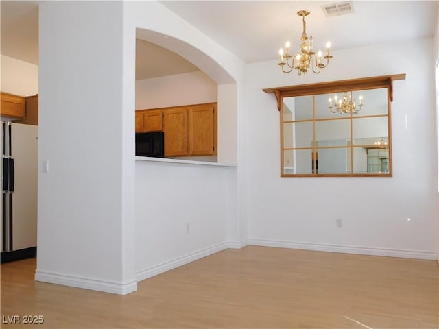 1128 Dusty Creek St, Las Vegas, NV 89128 - unfurnished dining area with a chandelier, light wood-type flooring, and arched walkways