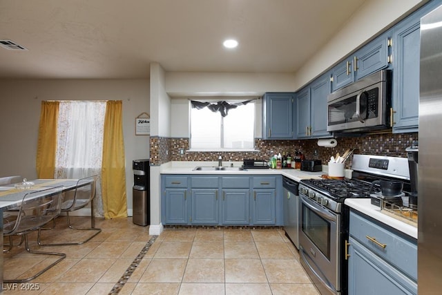 2912 Drury St, Las Vegas, NV 89108 - kitchen featuring appliances with stainless steel finishes, blue cabinetry, light tile patterned flooring, light countertops, and recessed lighting