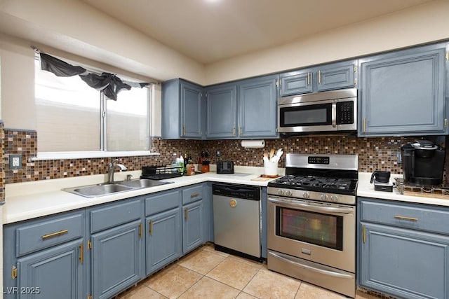 2912 Drury St, Las Vegas, NV 89108 - kitchen with stainless steel appliances, light tile patterned floors, blue cabinetry, light countertops, and decorative backsplash