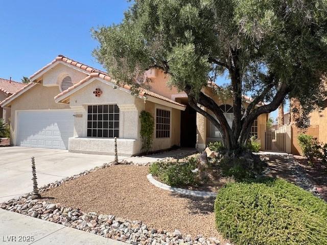 8404 Dry Cliff Cir, Las Vegas, NV 89128 - mediterranean / spanish-style house with a garage, concrete driveway, a tile roof, and stucco siding