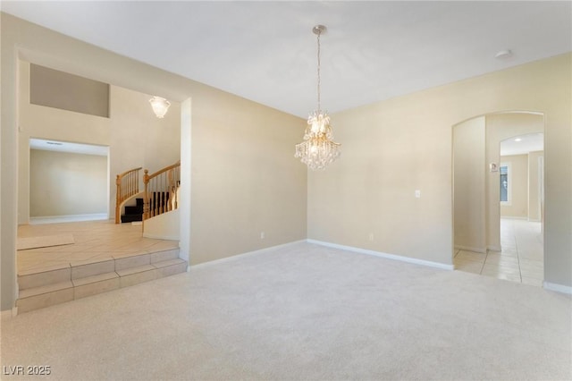 8901 Goldstone Ave, Las Vegas, NV 89143 - empty room featuring carpet flooring, stairs, tile patterned flooring, arched walkways, and a chandelier