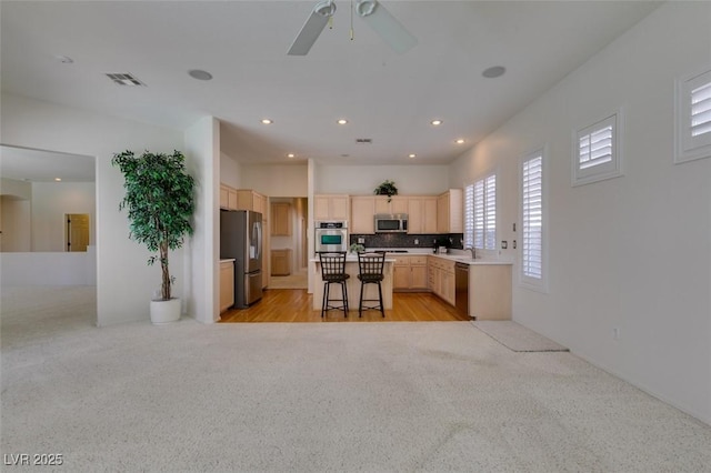 1414 Doggett Ave, Las Vegas, NV 89123 - kitchen with appliances with stainless steel finishes, light brown cabinets, light carpet, ceiling fan, and recessed lighting