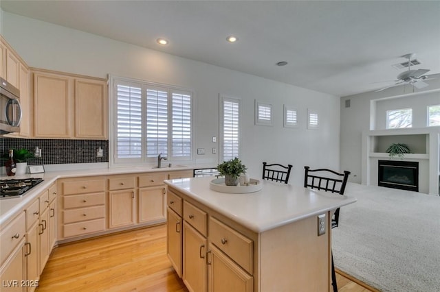 1414 Doggett Ave, Las Vegas, NV 89123 - kitchen featuring light brown cabinetry, recessed lighting, light countertops, and a breakfast bar area