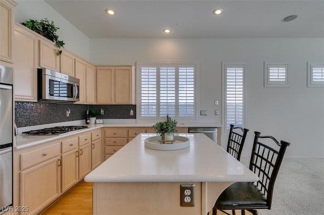 1414 Doggett Ave, Las Vegas, NV 89123 - kitchen with appliances with stainless steel finishes, a kitchen breakfast bar, recessed lighting, tasteful backsplash, and a center island