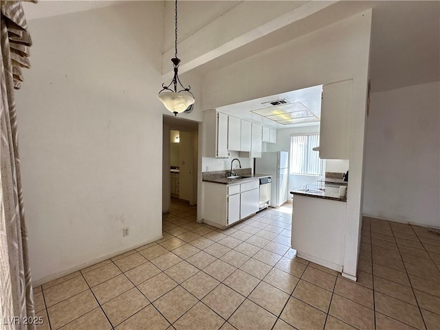 4320 Gannet Cir Unit 116, Las Vegas, NV 89103 - kitchen with light tile patterned flooring, freestanding refrigerator, white cabinetry, dishwasher, and dark countertops