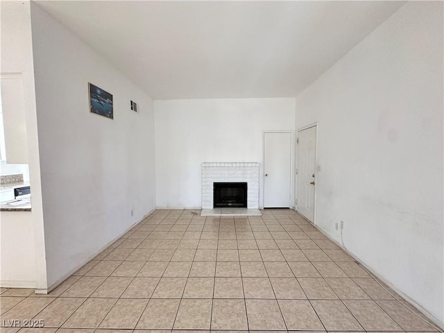 4320 Gannet Cir Unit 116, Las Vegas, NV 89103 - unfurnished living room featuring a fireplace and light tile patterned floors