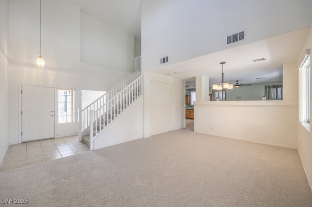 5209 Mantua Ct, Las Vegas, NV 89130 - carpeted entryway with a high ceiling, stairway, tile patterned flooring, and a chandelier