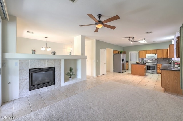 5209 Mantua Ct, Las Vegas, NV 89130 - kitchen featuring appliances with stainless steel finishes, open floor plan, dark countertops, light tile patterned floors, and a kitchen island