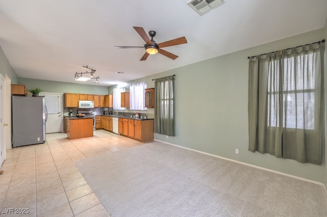 5209 Mantua Ct, Las Vegas, NV 89130 - kitchen featuring appliances with stainless steel finishes, dark countertops, a ceiling fan, light tile patterned floors, and open floor plan