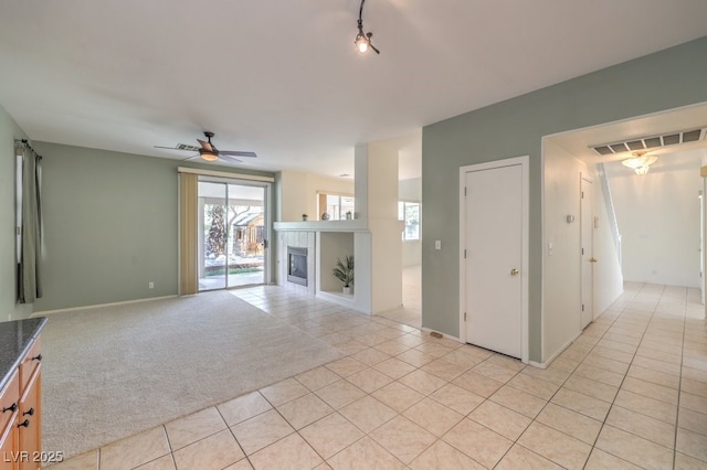 5209 Mantua Ct, Las Vegas, NV 89130 - unfurnished living room featuring light tile patterned floors, a ceiling fan, a fireplace, and light carpet
