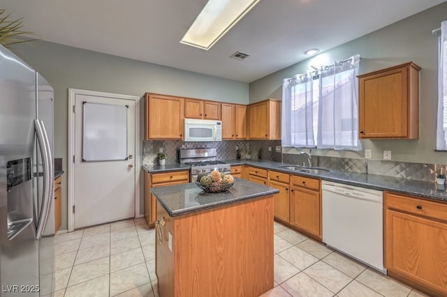 5209 Mantua Ct, Las Vegas, NV 89130 - kitchen featuring appliances with stainless steel finishes, decorative backsplash, a center island, and brown cabinetry