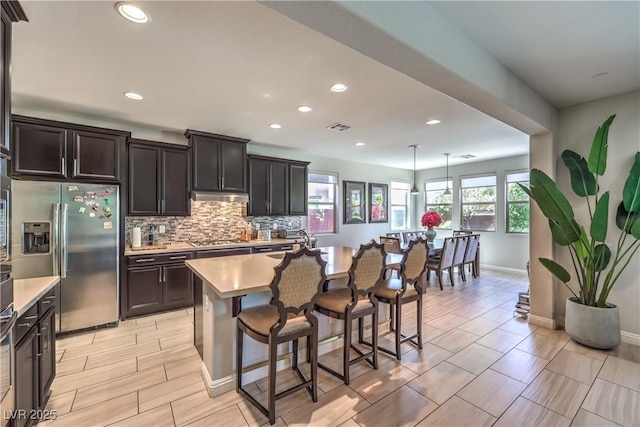 913 Silent Sunset Ave, North Las Vegas, NV 89084 - kitchen with appliances with stainless steel finishes, light countertops, backsplash, a breakfast bar, and recessed lighting