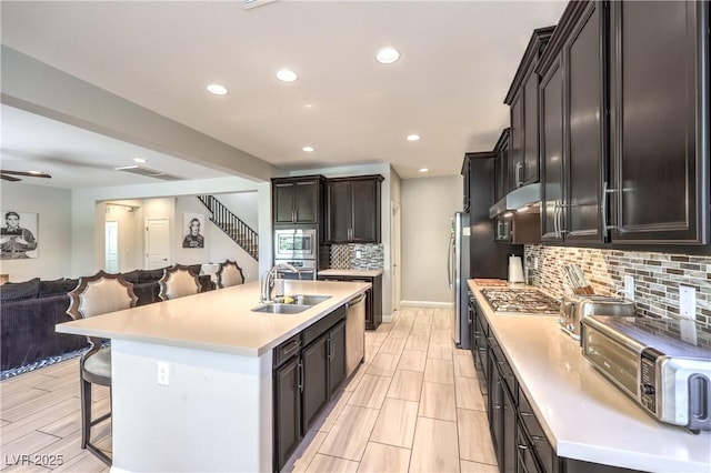 913 Silent Sunset Ave, North Las Vegas, NV 89084 - kitchen with appliances with stainless steel finishes, open floor plan, light countertops, a kitchen breakfast bar, and backsplash