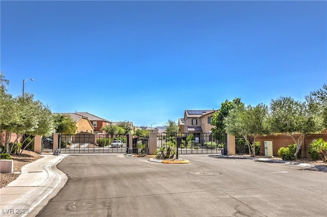 913 Silent Sunset Ave, North Las Vegas, NV 89084 - view of asphalt road featuring a gate, a gated entry, a residential view, and sidewalks