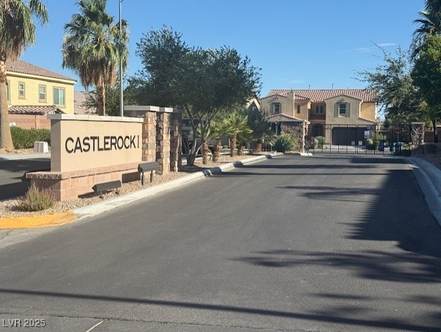 913 Silent Sunset Ave, North Las Vegas, NV 89084 - view of asphalt road featuring curbs, a gated entry, and a residential view