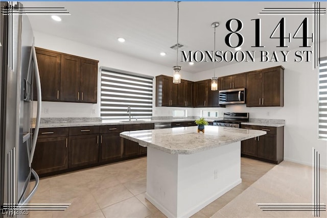 8144 Monsoon Bay St, Las Vegas, NV 89113 - kitchen featuring appliances with stainless steel finishes, dark brown cabinets, hanging light fixtures, a kitchen island, and recessed lighting