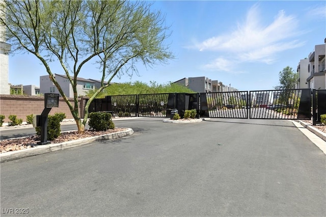 8144 Monsoon Bay St, Las Vegas, NV 89113 - view of asphalt road featuring a gate, a gated entry, curbs, and a residential view