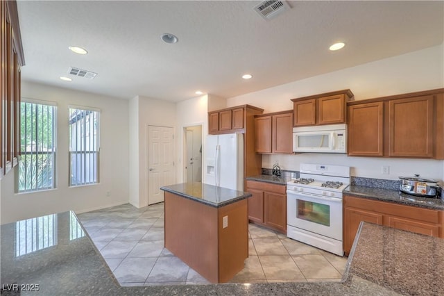 3813 Jasmine Heights Ave, North Las Vegas, NV 89081 - kitchen with white appliances, brown cabinets, light tile patterned flooring, a kitchen island, and recessed lighting