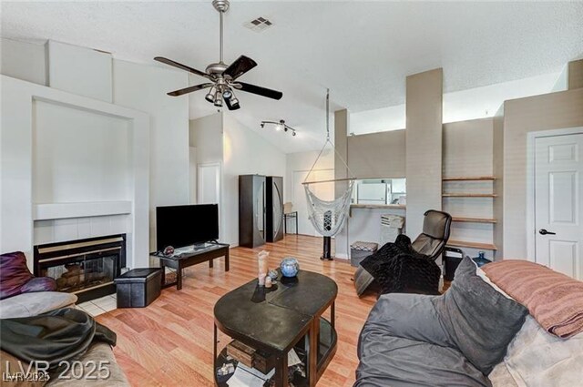 1600 N Torrey Pines Dr Unit 202, Las Vegas, NV 89108 - living room with a ceiling fan, light wood-style floors, a tiled fireplace, and high vaulted ceiling