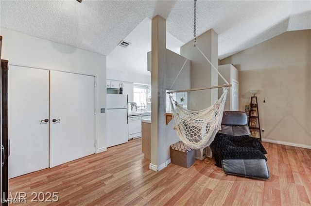 1600 N Torrey Pines Dr Unit 202, Las Vegas, NV 89108 - living area featuring light wood-style floors, vaulted ceiling, and a textured ceiling