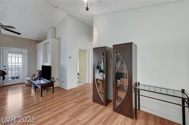 1600 N Torrey Pines Dr Unit 202, Las Vegas, NV 89108 - living area featuring light wood-type flooring, ceiling fan, a textured ceiling, and high vaulted ceiling