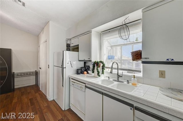 1600 N Torrey Pines Dr Unit 202, Las Vegas, NV 89108 - kitchen with white appliances, white cabinets, tile counters, dark wood-style flooring, and vaulted ceiling