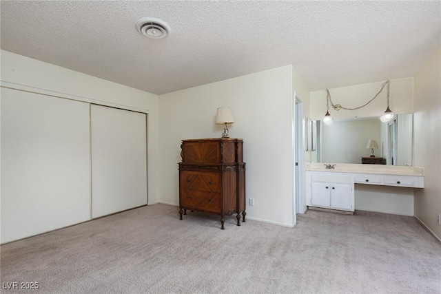 2157 Mccoig Ave, Las Vegas, NV 89119 - bedroom with light carpet, a closet, a textured ceiling, and built in study area
