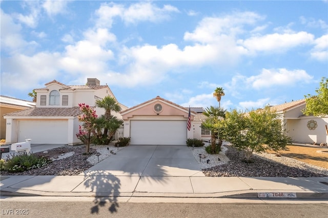 7048 Harbor View Dr, Las Vegas, NV 89119 - mediterranean / spanish house with stucco siding, concrete driveway, a garage, a tiled roof, and solar panels