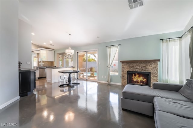 7048 Harbor View Dr, Las Vegas, NV 89119 - living area with finished concrete flooring, a chandelier, a stone fireplace, vaulted ceiling, and recessed lighting
