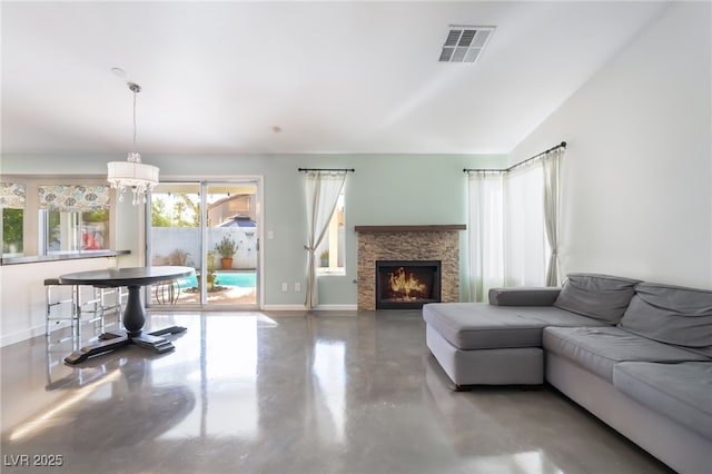 7048 Harbor View Dr, Las Vegas, NV 89119 - living room featuring finished concrete floors, a chandelier, a fireplace, and lofted ceiling