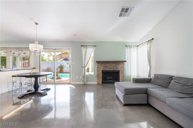 7048 Harbor View Dr, Las Vegas, NV 89119 - living area featuring concrete flooring, a chandelier, and a stone fireplace