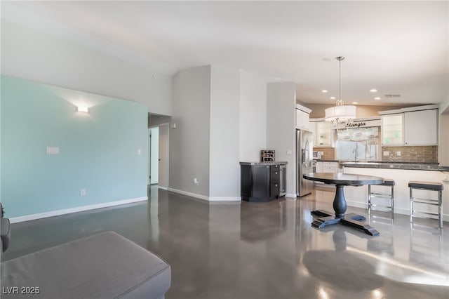 7048 Harbor View Dr, Las Vegas, NV 89119 - kitchen featuring stainless steel refrigerator with ice dispenser, concrete floors, recessed lighting, white cabinetry, and backsplash