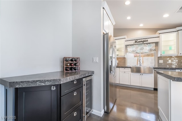 7048 Harbor View Dr, Las Vegas, NV 89119 - kitchen featuring appliances with stainless steel finishes, wine cooler, dark countertops, tasteful backsplash, and recessed lighting